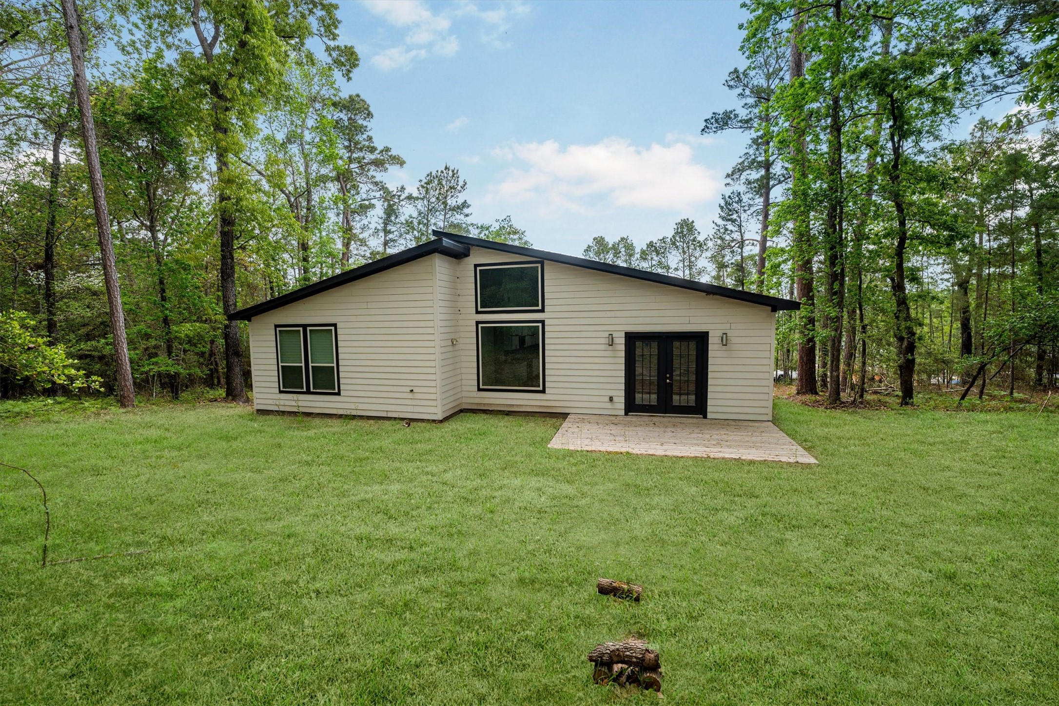 24411 Oakaland Hls Road Point Blank, TX 77364 - Photo 36 of 40 a view of a backyard with plants and large tree