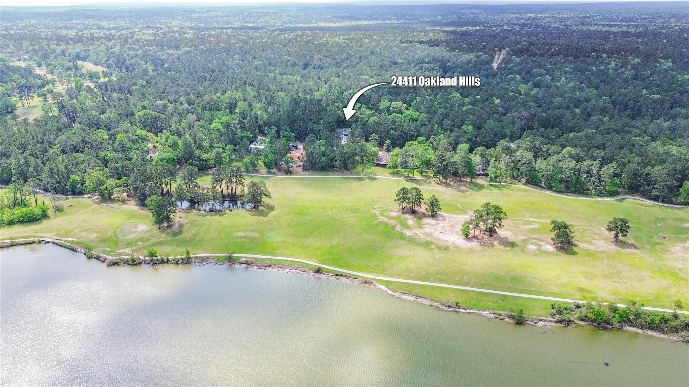 24411 Oakaland Hls Road Point Blank, TX 77364 - Photo 4 of 40 a view of a house with a yard and lake view