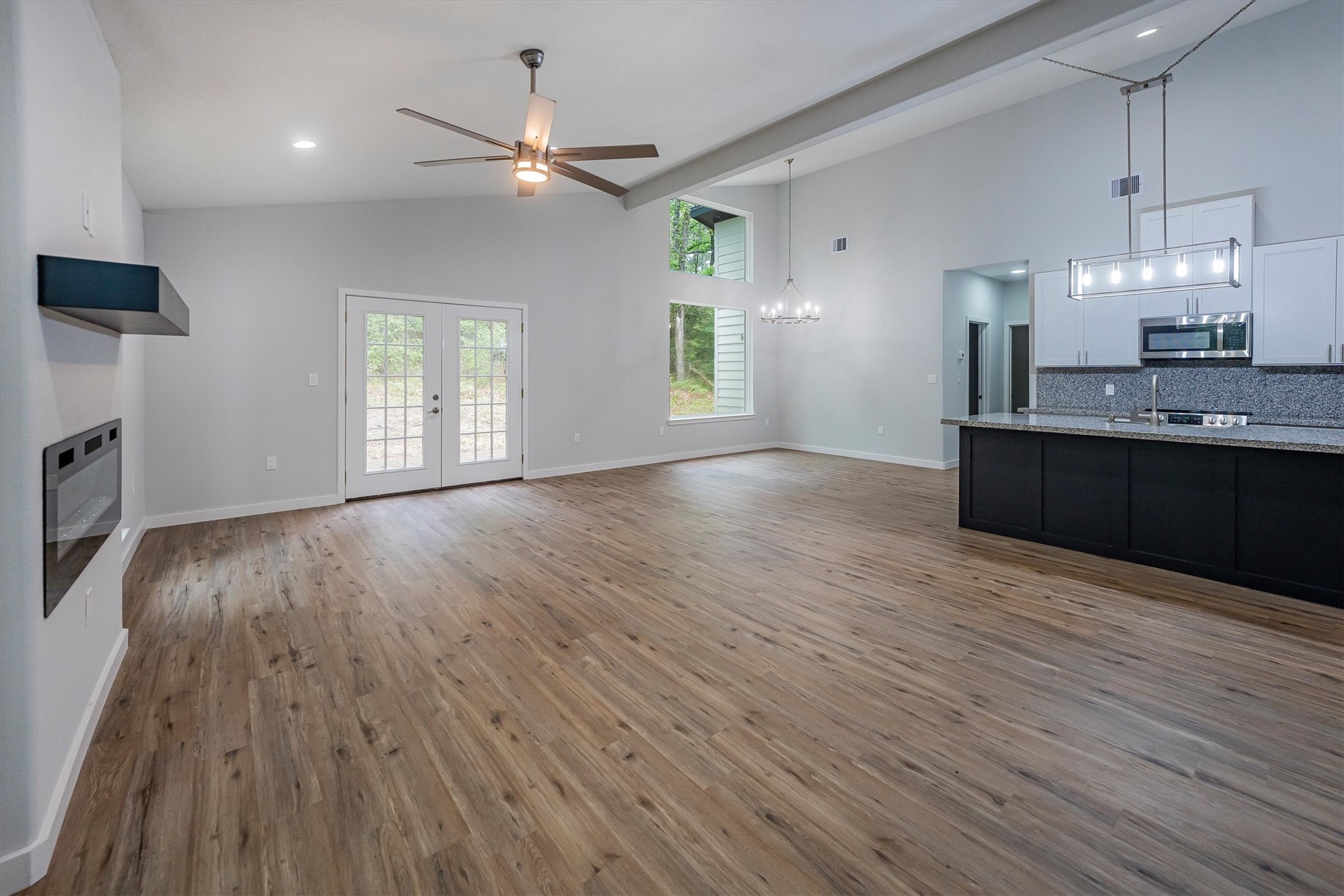 24411 Oakaland Hls Road Point Blank, TX 77364 - Photo 7 of 40 a view of kitchen and empty room with wooden floor