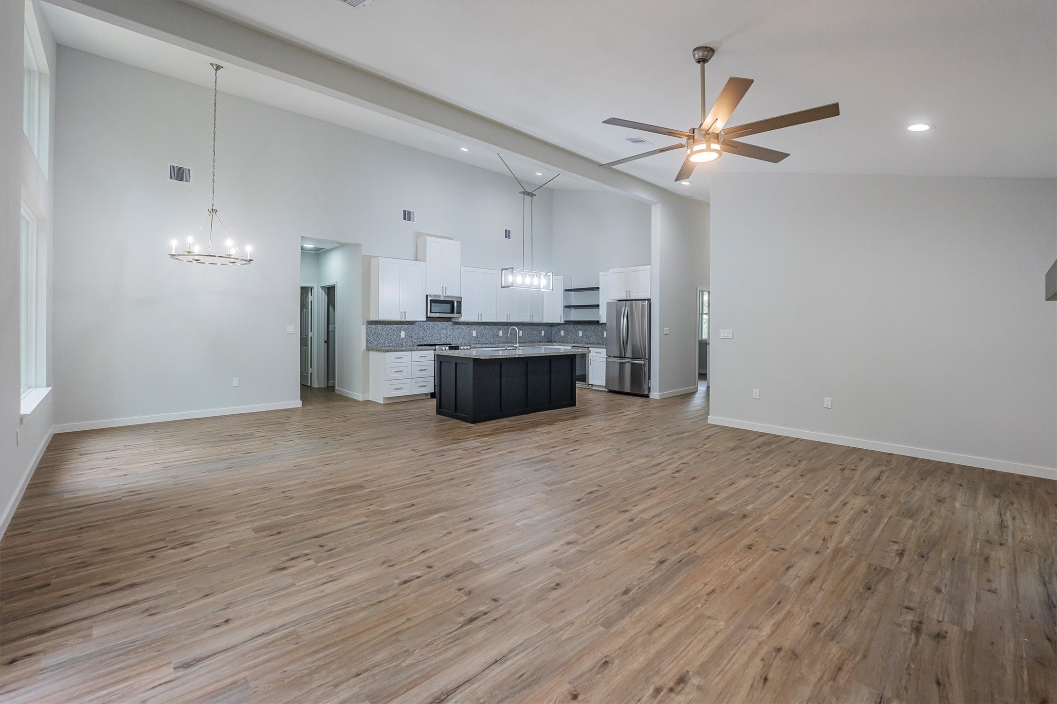 24411 Oakaland Hls Road Point Blank, TX 77364 - Photo 8 of 40 a view of a livingroom with a ceiling fan wooden floor and window