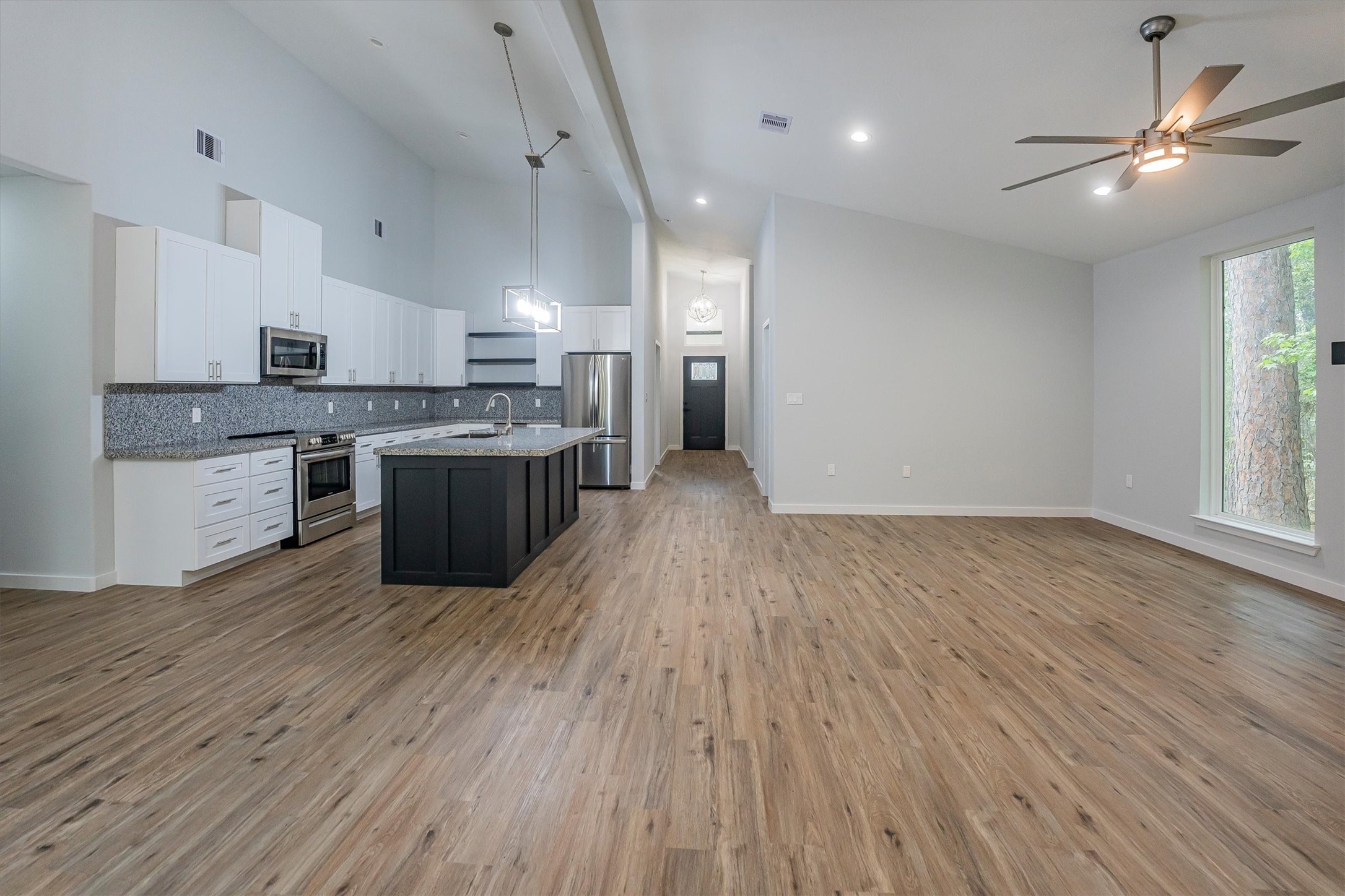 24411 Oakaland Hls Road Point Blank, TX 77364 - Photo 10 of 40 a large kitchen with stainless steel appliances granite countertop a stove and a wooden floors