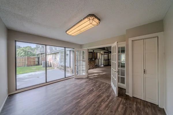 a view of empty room with wooden floor and fan