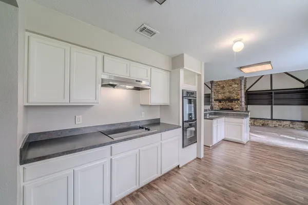a kitchen with white cabinets and stainless steel appliances