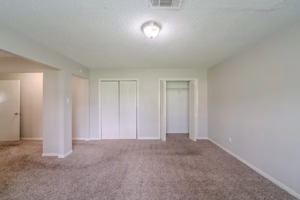 an empty room with closet and windows