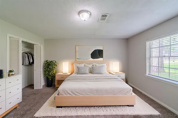 a bedroom with a large bed and potted plant