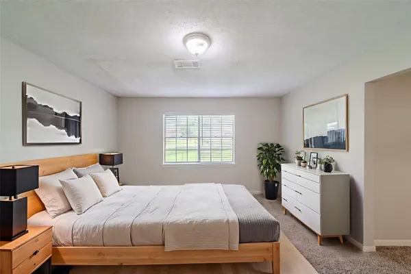 a bedroom with a large bed and a potted plant