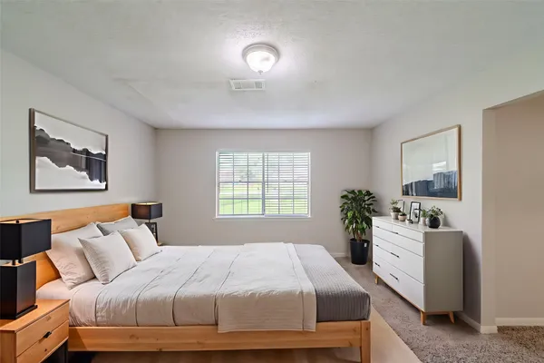 a bedroom with a large bed and a potted plant