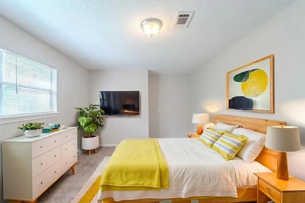 a bedroom with a bed and a flat screen tv