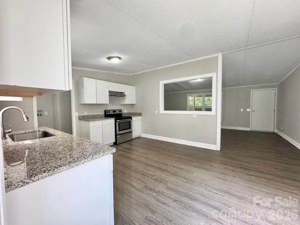 a kitchen with granite countertop a stove and a sink