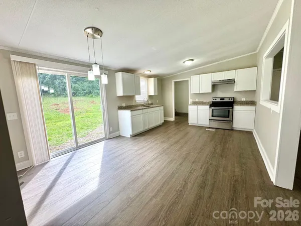 a large kitchen with a wooden floor and outdoor space
