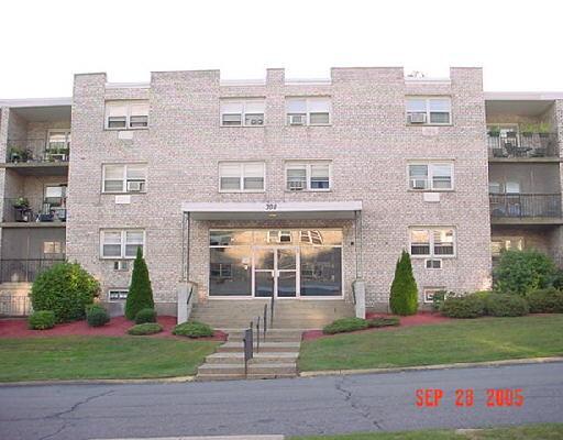 308 Meadowside Road, Unit 310 Milford, CT 06460 - Photo 1 of 1 a view of a brick building next to a yard