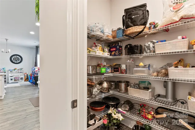 a room with stainless steel appliances and wooden floor