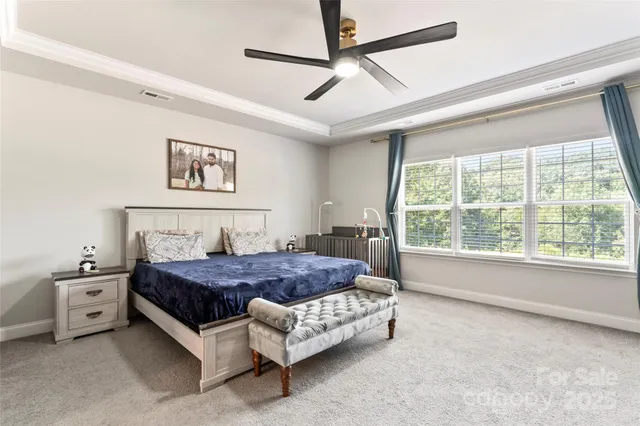 a bedroom with a bed painting on the wall and a large window