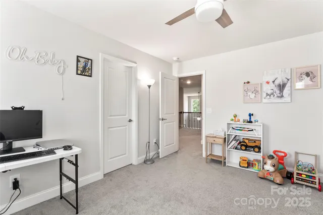 a view of a workspace with furniture and a ceiling fan