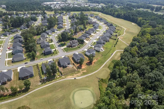 an aerial view of a house with a yard and lake
