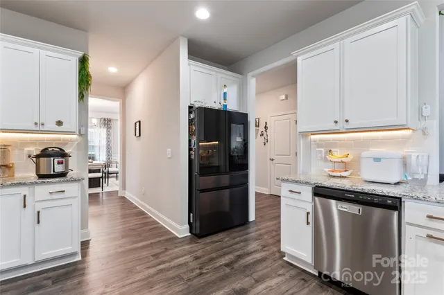 a kitchen with granite countertop a refrigerator and a sink