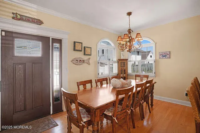a dining room with furniture a chandelier and wooden floor