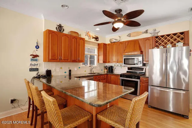 a kitchen with stainless steel appliances a refrigerator a sink a stove a table and chairs