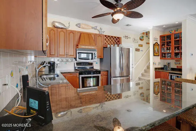 a kitchen with stainless steel appliances granite countertop a stove refrigerator and a sink