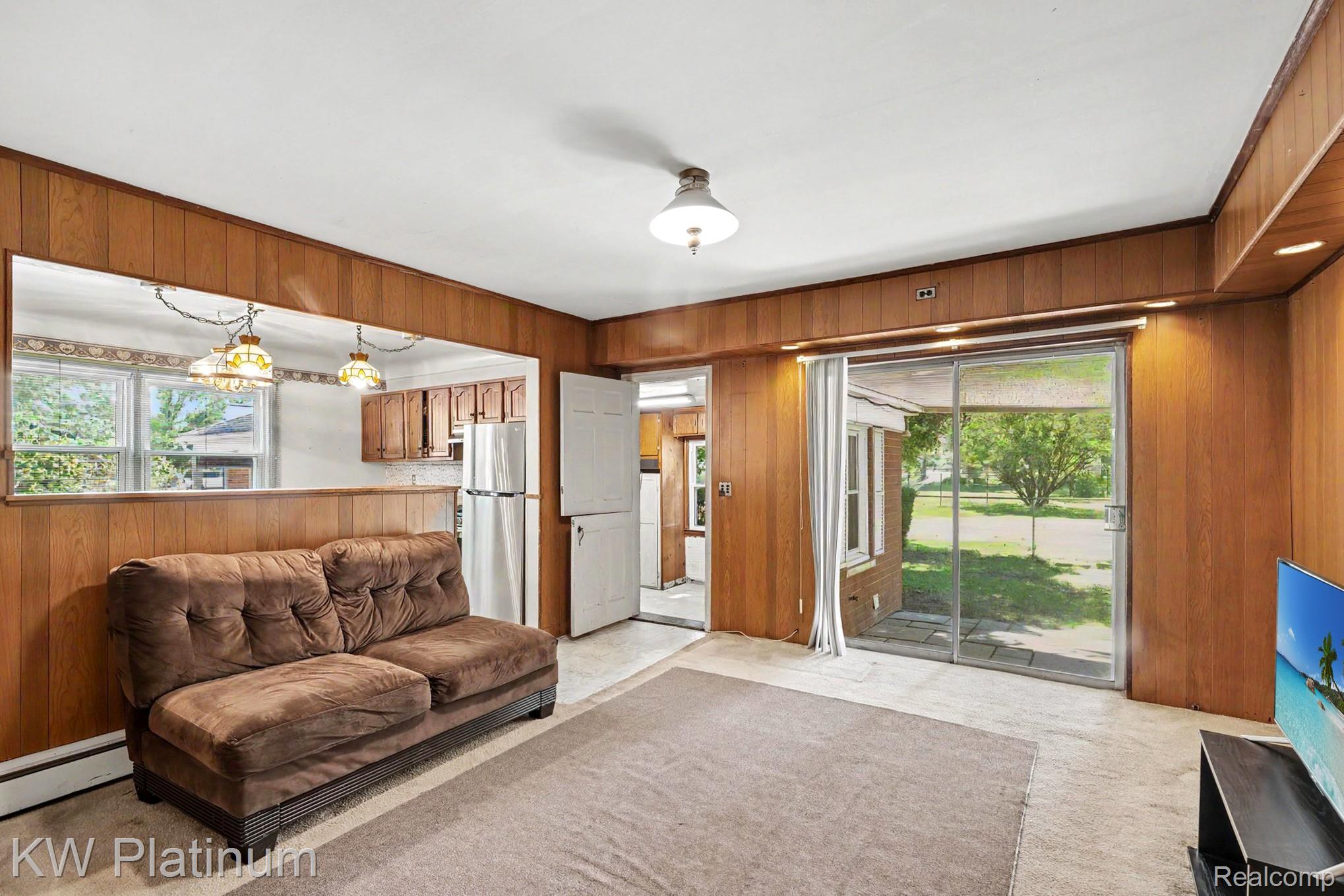 33200 Edgegrove Road Fraser, MI 48026 - Photo 14 of 26 Sliding glass door, wood paneling, recessed lighting, and an overhead light fixture