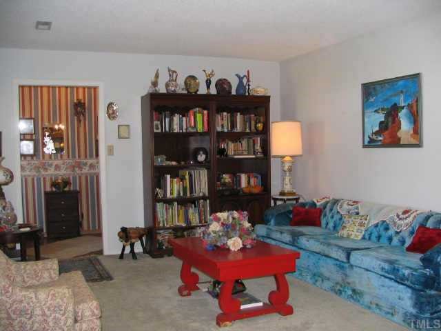 901 Buckhorn Road Garner, NC 27529 - Photo 6 of 6 a living room with furniture a rug and a chandelier