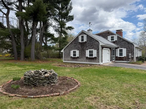 a view of a yard in front of a house with large trees