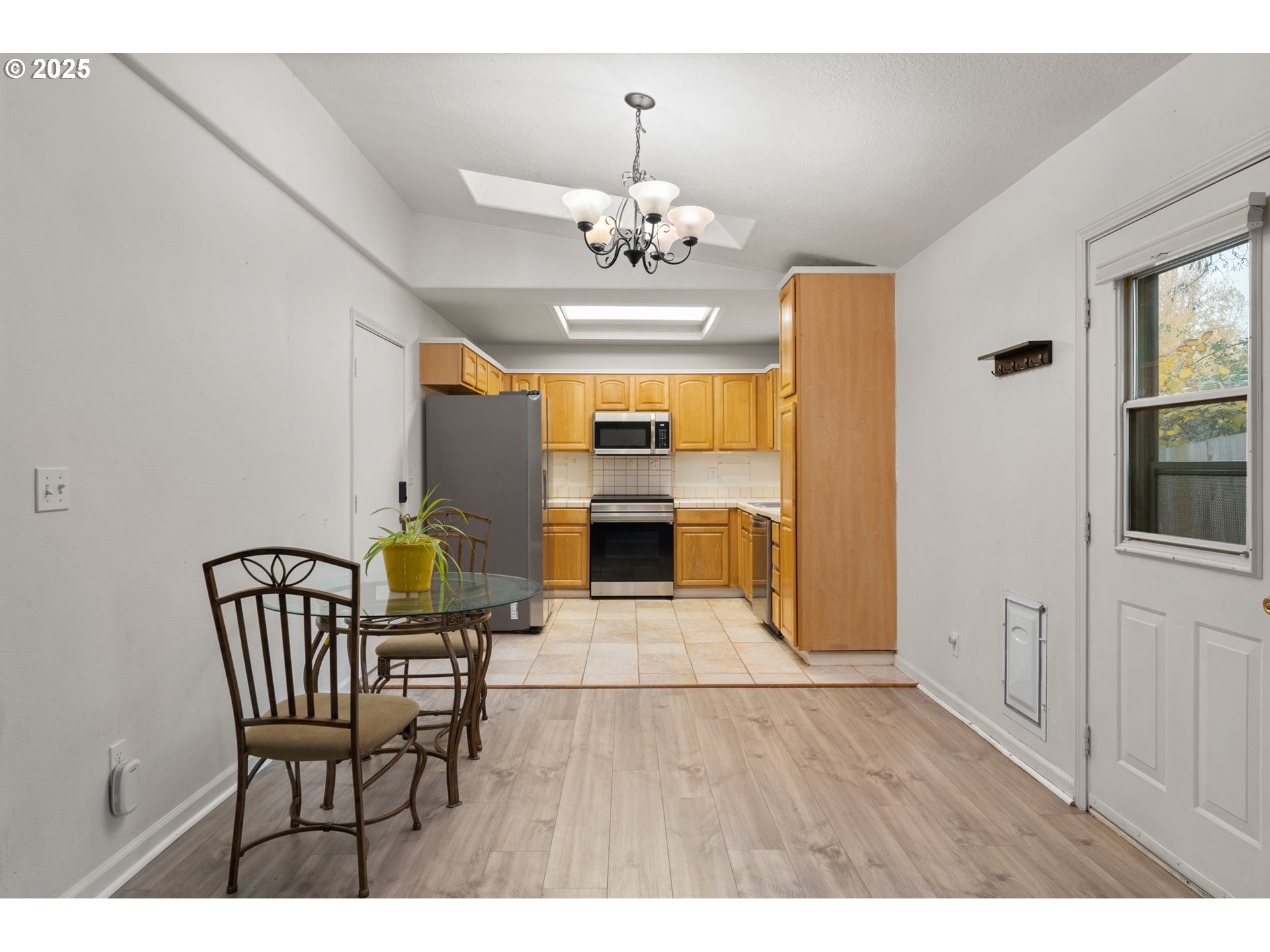 618 Northeast Faloma Road Portland, OR 97211 - Photo 7 of 24 a view of a dining room with furniture a chandelier and wooden floor