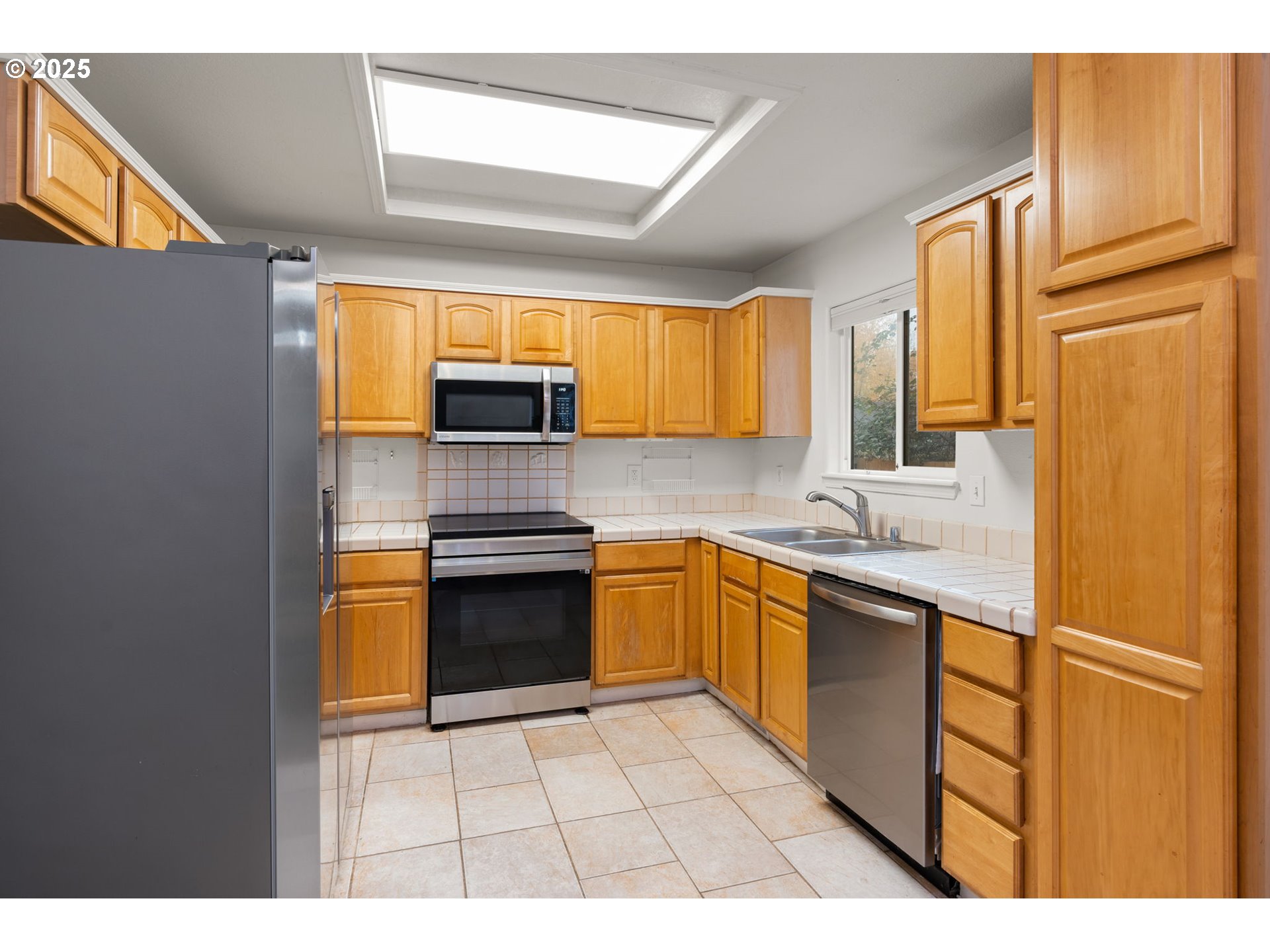618 Northeast Faloma Road Portland, OR 97211 - Photo 8 of 24 a kitchen with stainless steel appliances granite countertop a refrigerator a sink dishwasher a stove with wooden cabinets