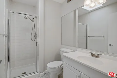 a bathroom with a granite countertop sink toilet and shower