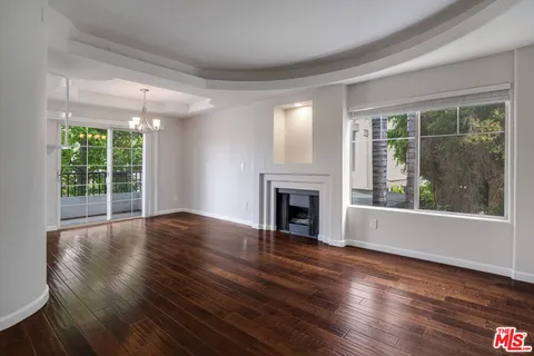 a view of empty room with wooden floor and fireplace