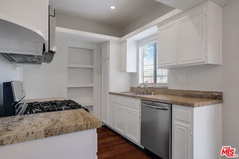 a kitchen with a sink stove and cabinets