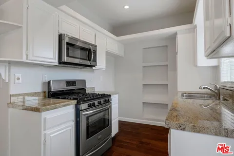 a kitchen with granite countertop a sink and steel appliances