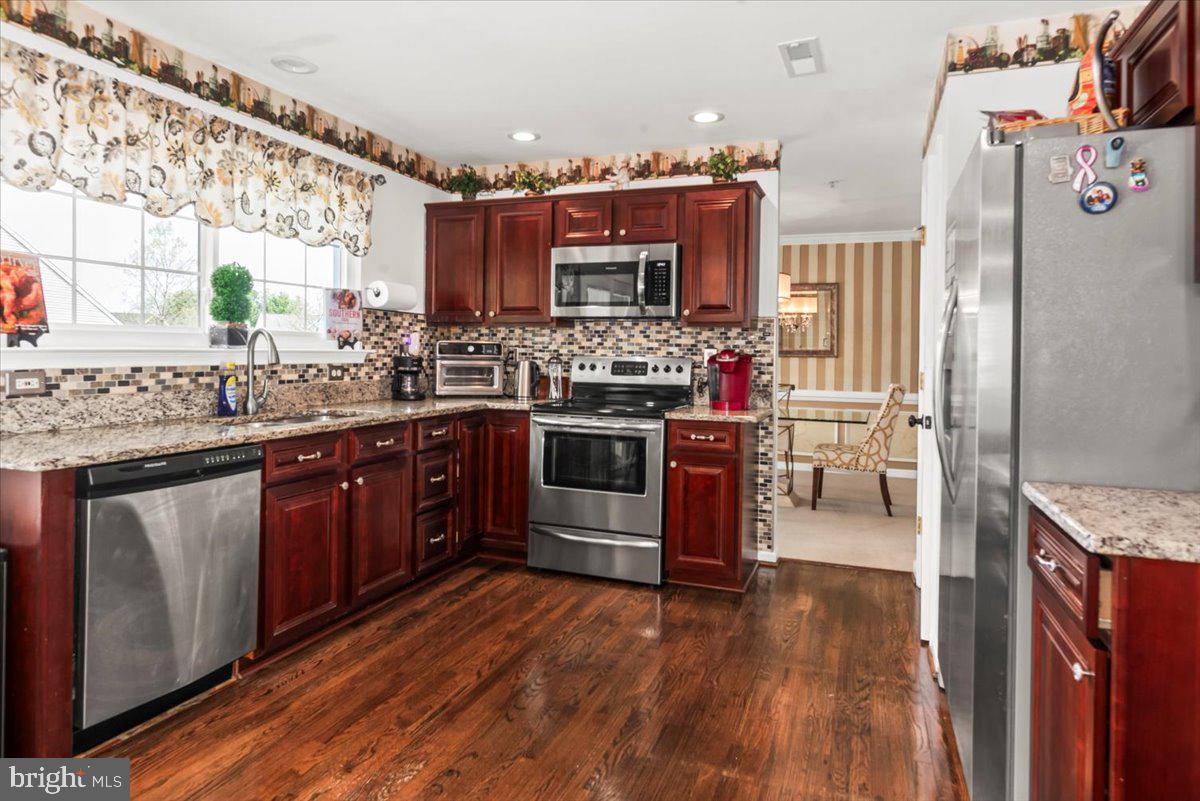 16308 Eddinger Road Bowie, MD 20716 - Photo 8 of 45 a kitchen with stainless steel appliances granite countertop a stove and a refrigerator