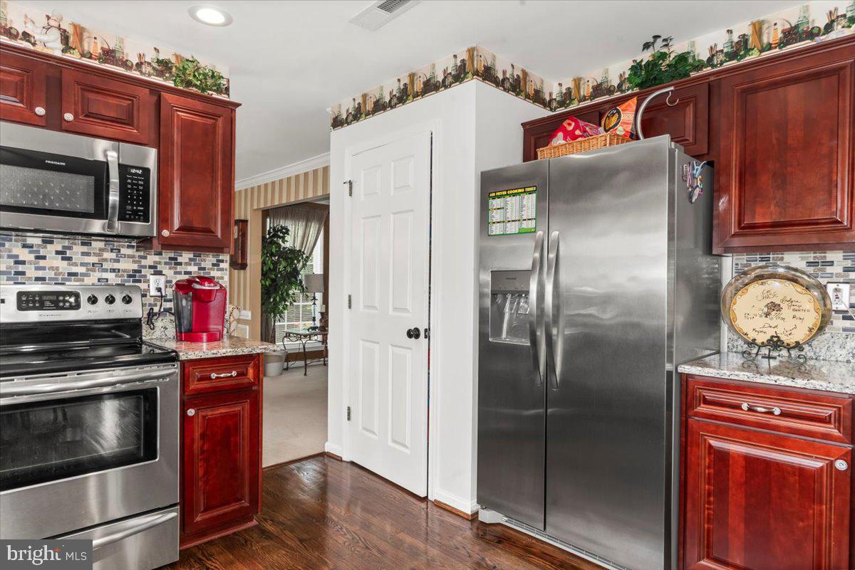 16308 Eddinger Road Bowie, MD 20716 - Photo 9 of 45 a kitchen with stainless steel appliances granite countertop a refrigerator and a stove