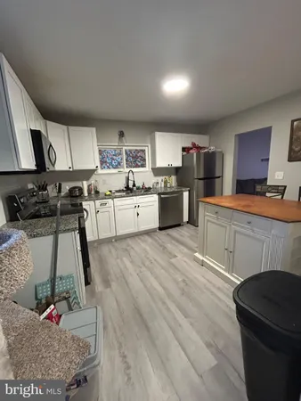 a kitchen that has a lot of cabinets a sink and appliances in it