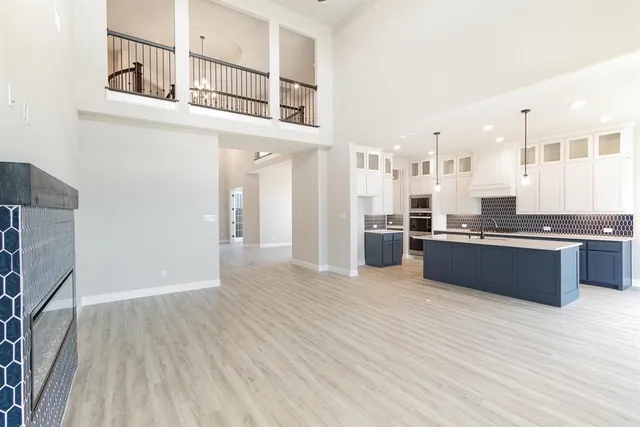 a large white kitchen with stainless steel appliances granite countertop a refrigerator and a sink
