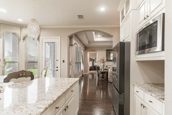 a view of a kitchen with kitchen island granite countertop a large window a sink and stainless steel appliances