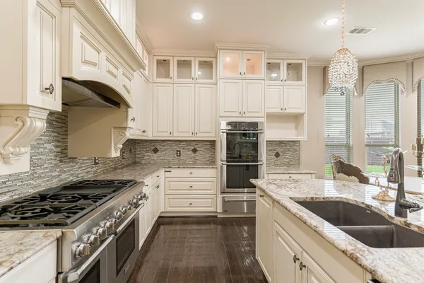 a kitchen with stainless steel appliances kitchen island granite countertop a sink stove and cabinets