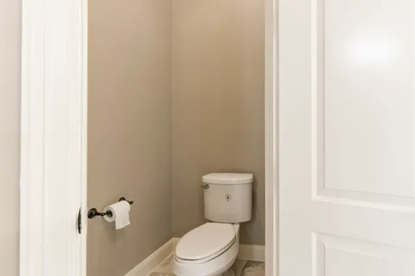 a white toilet sitting next to a white cabinet