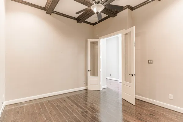 a view of an empty room with wooden floor