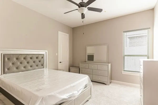 a bedroom with a bed and a window