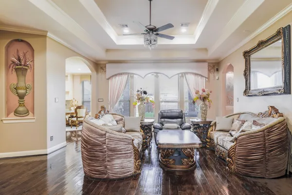 a living room with furniture a wooden floor and a chandelier