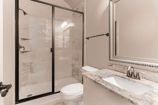 a bathroom with a granite countertop sink toilet and shower