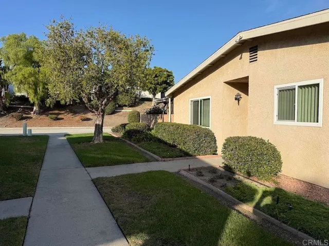 a front view of a house with a yard and trees