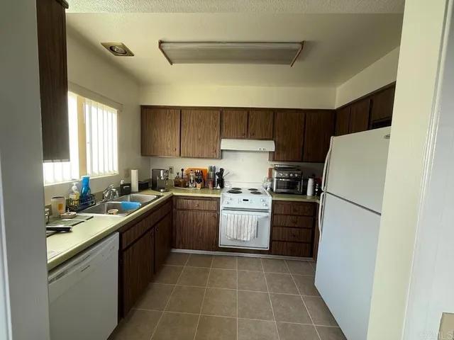 a kitchen with a white stove top oven and refrigerator