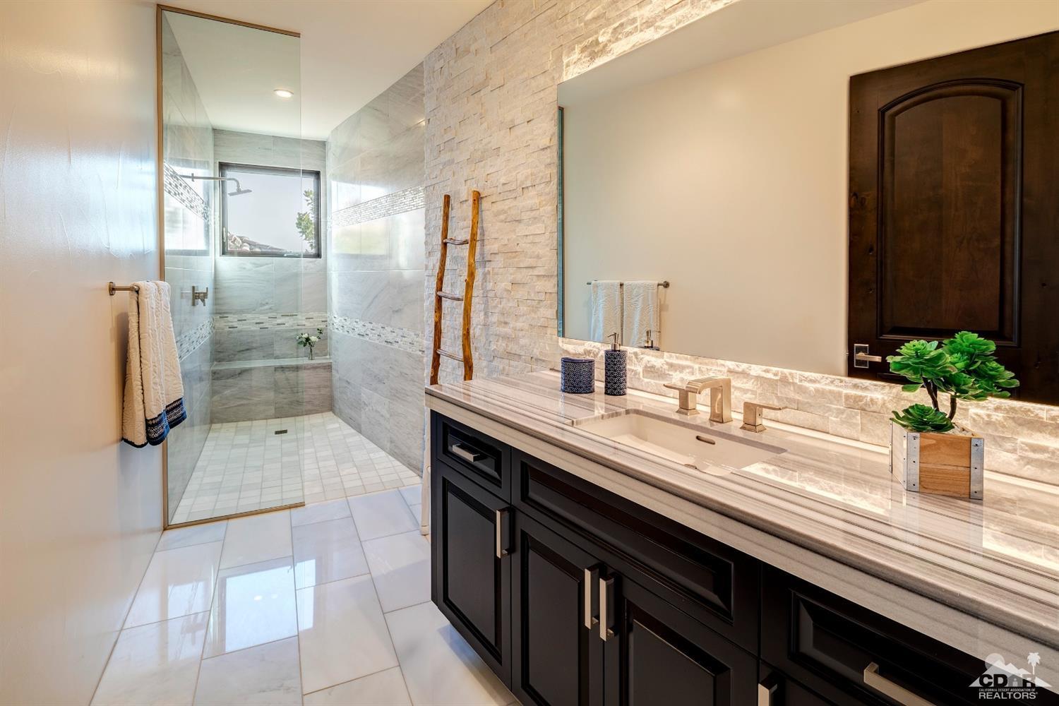 18 Rockcrest Drive Rancho Mirage, CA 92270 - Photo 33 of 35 a bathroom with a granite countertop sink a mirror and shower