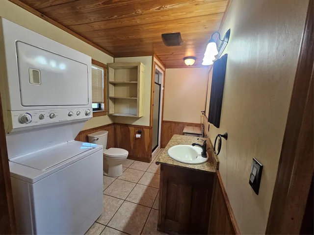 a bathroom with a sink a toilet a mirror and shower