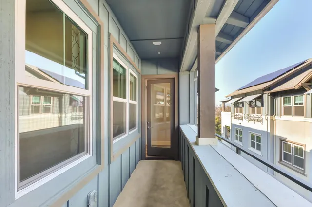 a view of a hallway with wooden floor and white walls