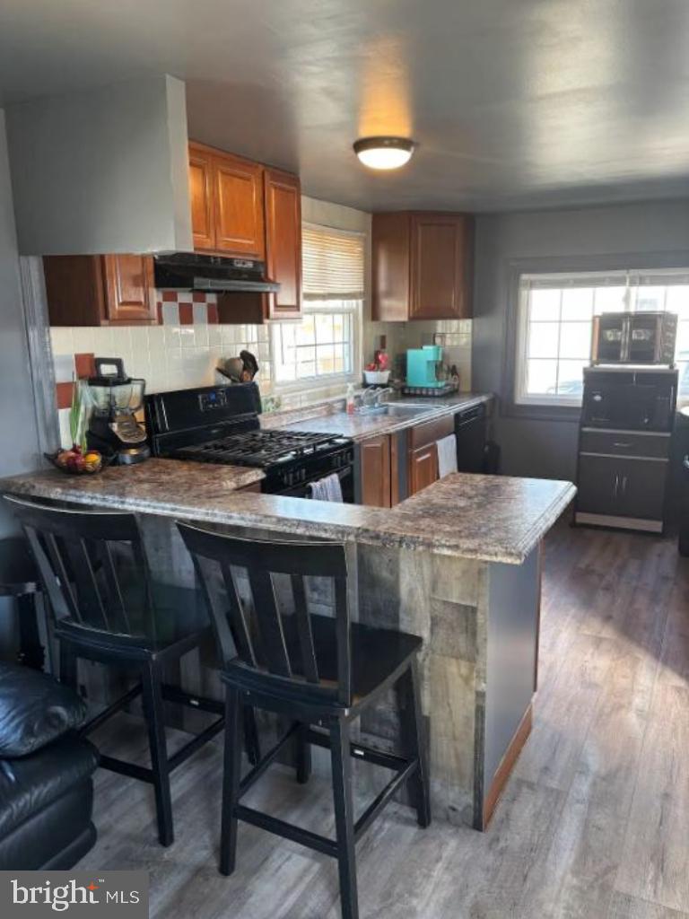 1762 Crown Point Road, Unit 33WS Thorofare, NJ 08086 - Photo 12 of 29 a kitchen with stainless steel appliances granite countertop a stove a sink dishwasher a dining table and chairs with wooden floor