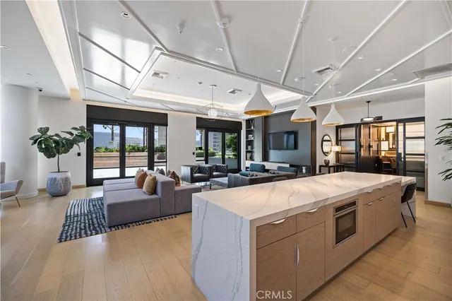 a large living room with stainless steel appliances furniture stove and a kitchen view